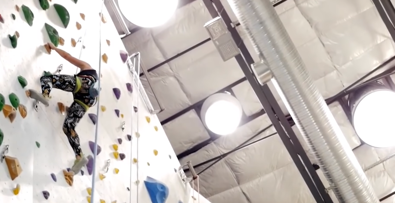 View from the ground of three large tubular daylighting devices on the ceiling of an indoor wall climbing facility