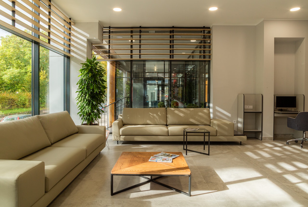 Natural lighting entering a receiving area with two couches via vertical glass panels
