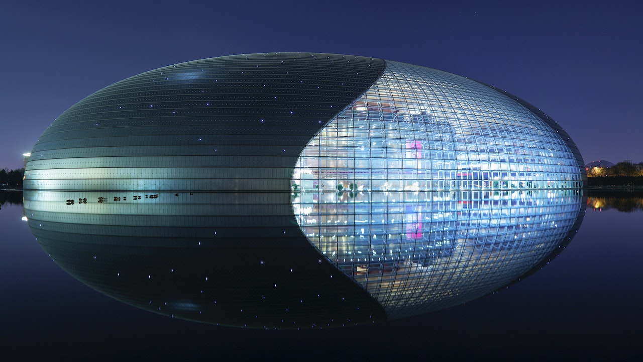 The illuminated National Center for the Performing Arts at night in Beijing, with its reflection on the water