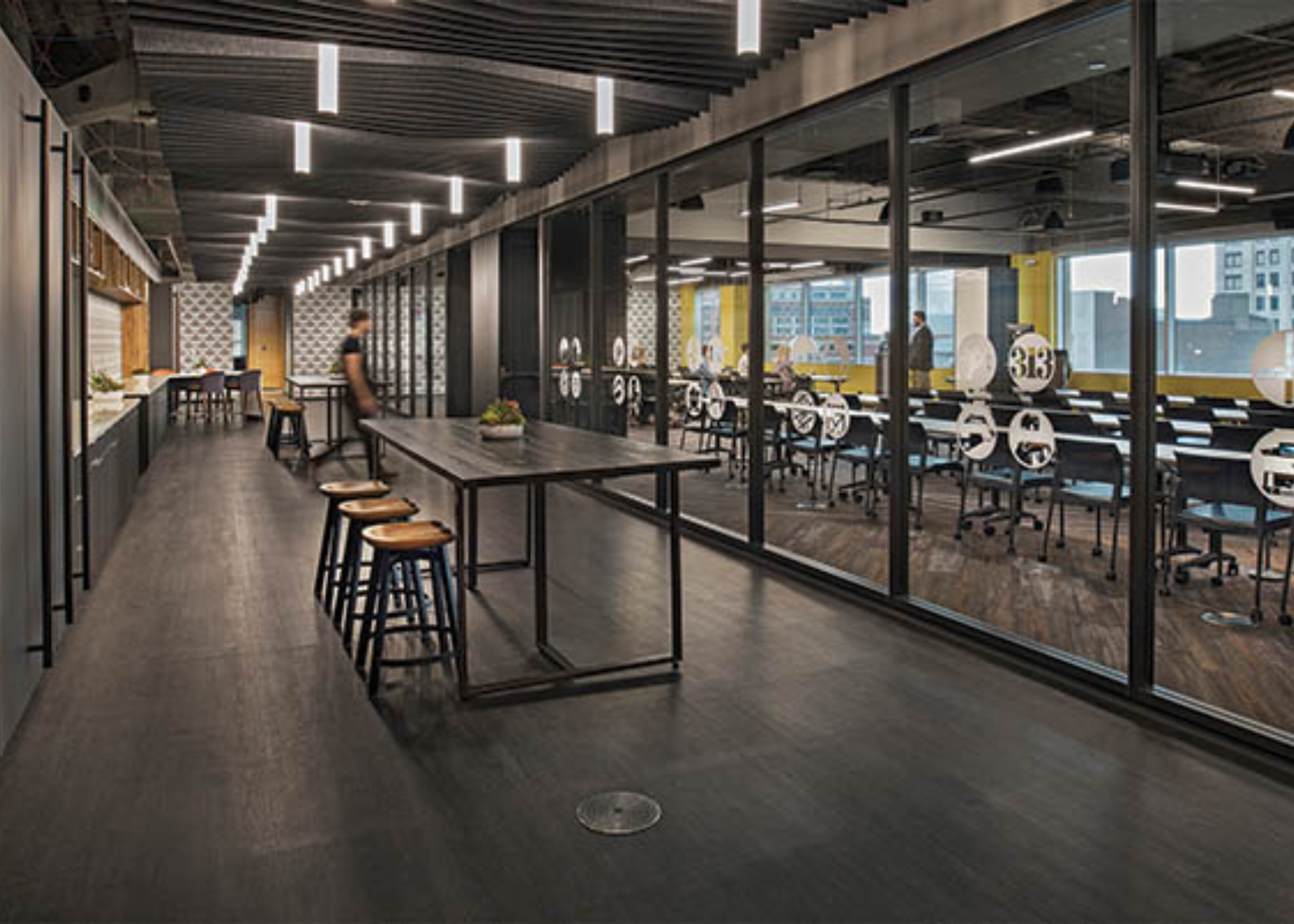 Lumistik CL322, a cylindrical pendant with a 3-in. dia. and a diffused acrylic lens, provides ambient light and aesthetics. Thirty pendants form two rows, interspersed with acoustic ceiling accents that emulate a “wave"