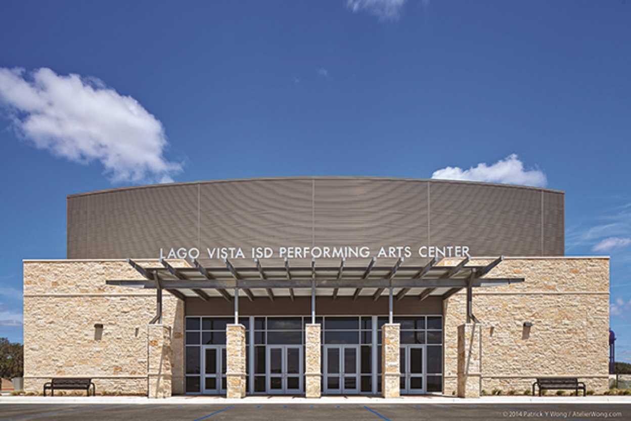 The stone-and-glass façade of the Lago Vista Performing Arts Center, with four main doors